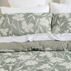Close-up of the green and white floral duvet cover set with matching pillowcases and a soft sage green reverse.
