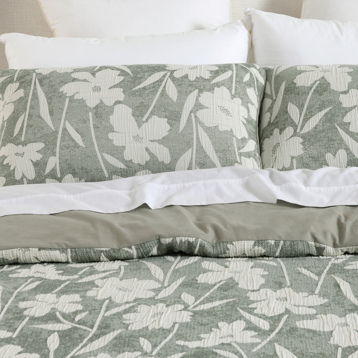 Close-up of the green and white floral duvet cover set with matching pillowcases and a soft sage green reverse.