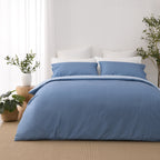 Front view of the Solace Arden Reversible Duvet Cover Set in blue, showing the deep blue duvet cover and matching pillowcases with the lighter blue reverse folded over at the top.