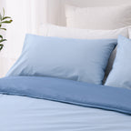 Close-up of the lighter blue reverse side of the Solace Arden Reversible Duvet Cover Set with coordinating light blue pillowcases and deep blue trim.