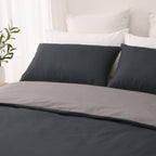 Close-up of the charcoal side of the Solace Arden Reversible Duvet Cover Set with coordinating charcoal pillowcases and the silver reverse folded over.