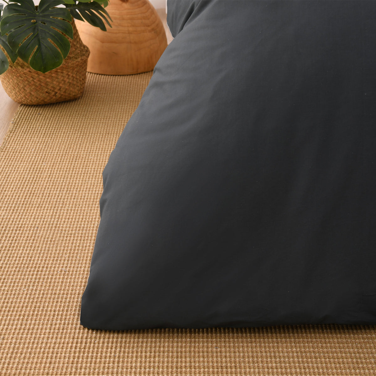 Close-up of the charcoal fabric of the Solace Arden Reversible Duvet Cover Set, showing its smooth plain finish.