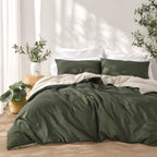 Solace Arden Reversible Duvet Cover Set styled in a green and natural colourway, featuring deep green bedding with a natural-toned reverse and coordinating pillowcases.