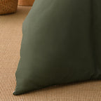 Close-up of the deep green fabric of the Solace Arden Reversible Duvet Cover Set, showing its smooth plain finish.