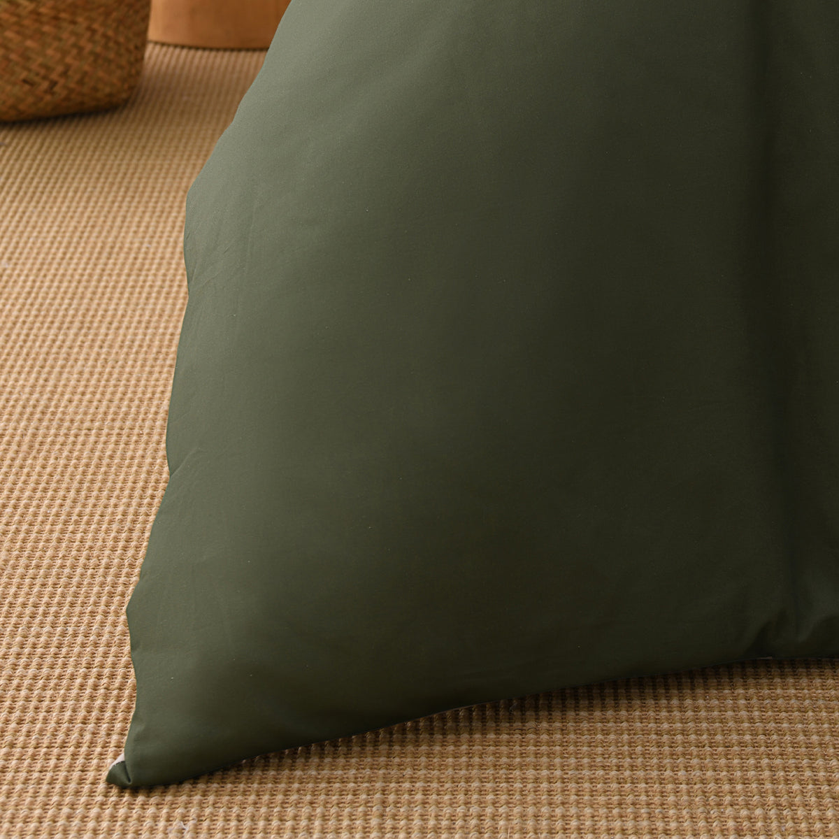 Close-up of the deep green fabric of the Solace Arden Reversible Duvet Cover Set, showing its smooth plain finish.