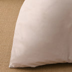 Close-up of the natural-coloured fabric of the Solace Arden Reversible Duvet Cover Set, showing its smooth plain finish and soft drape.