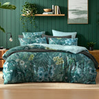 Logan & Mason Lila Surf 100% Cotton Duvet Cover Set in Green featuring a tropical floral and foliage print in shades of green, teal and blue, styled with matching pillowcases and charcoal bedding.