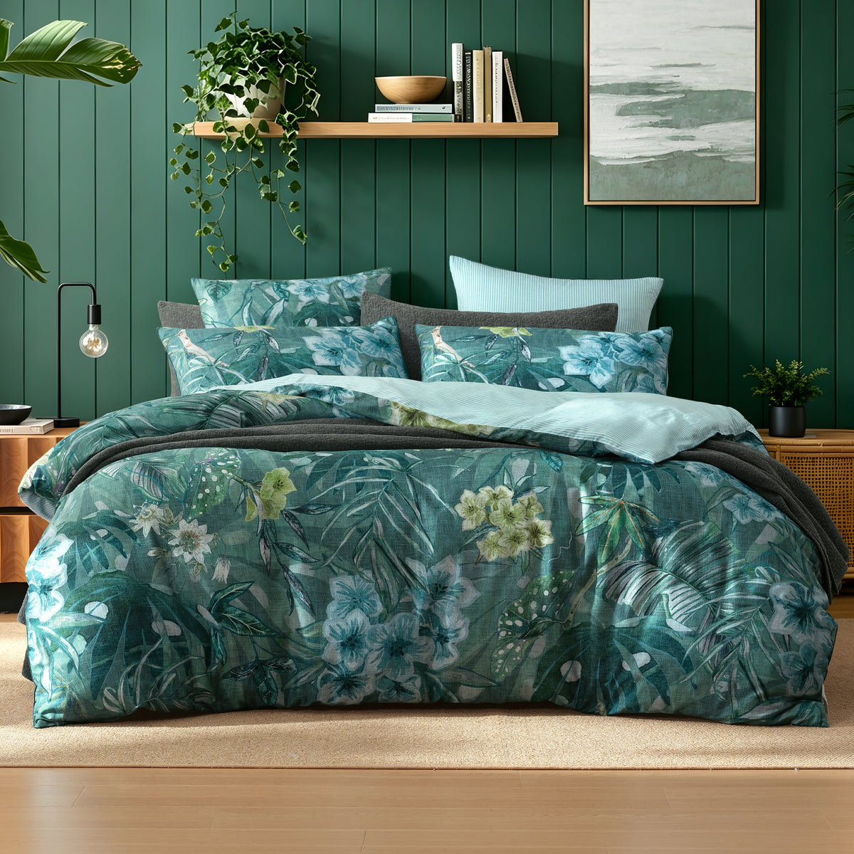 Logan & Mason Lila Surf 100% Cotton Duvet Cover Set in Green featuring a tropical floral and foliage print in shades of green, teal and blue, styled with matching pillowcases and charcoal bedding.