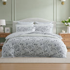 Private Collection Hydrangea 100% Cotton Duvet Cover Set featuring a soft grey and white hydrangea floral design, styled with coordinating pillowcases and white bedding in an elegant bedroom.