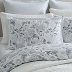 Close-up of the Private Collection Hydrangea Duvet Cover Set with matching floral pillowcases, soft grey striped European pillowcases and layered white bedding.