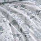 Close-up of the Private Collection Hydrangea Duvet Cover Set, showcasing the delicate grey hydrangea flowers and leafy botanical pattern on a white background.