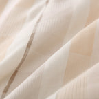 Close-up of a matching pillowcase featuring the cream, beige and grey striped jacquard design.
