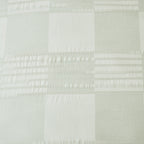 Baker St. Linen Zane Cotton Jacquard Duvet Cover Set in Sage styled on a bed with matching pillowcases, showcasing its soft green check design and textured detailing.