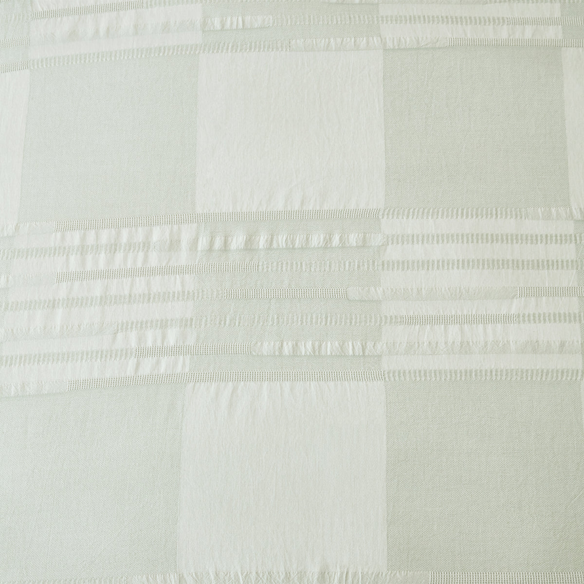 Baker St. Linen Zane Cotton Jacquard Duvet Cover Set in Sage styled on a bed with matching pillowcases, showcasing its soft green check design and textured detailing.