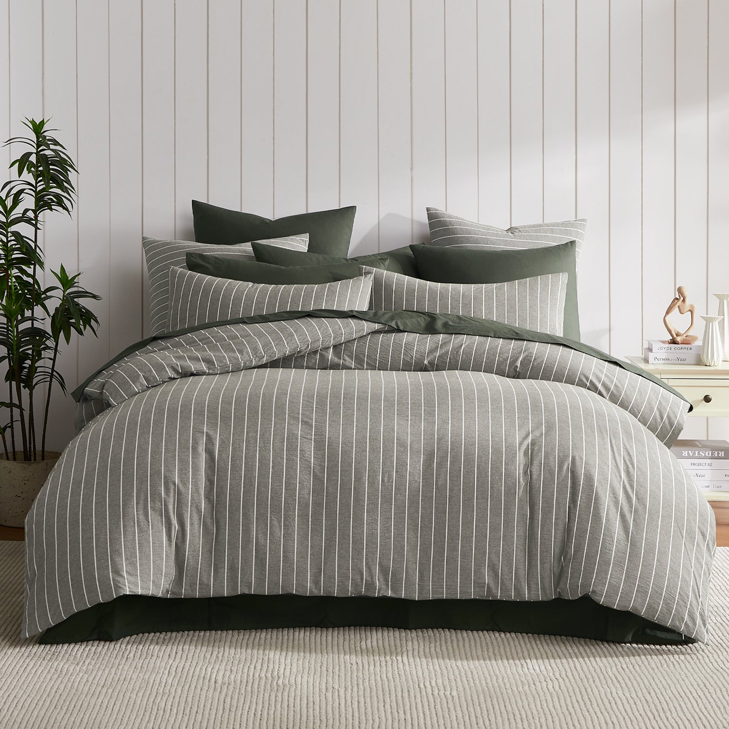 A beautifully layered bed featuring a thyme and white pinstripe duvet cover paired with deep thyme green bedding creates a relaxed, contemporary bedroom with timeless appeal.