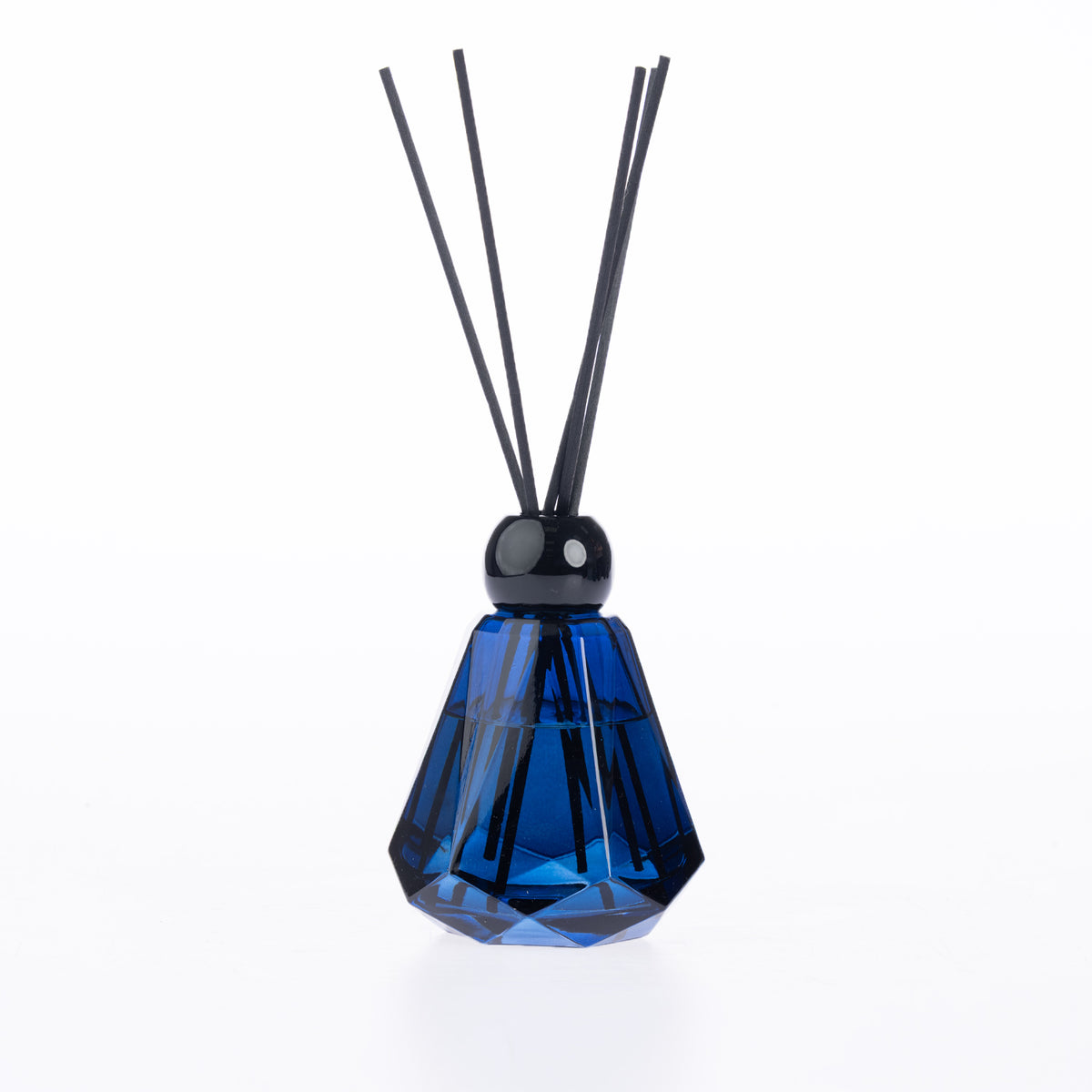 Design Plus Home Opulence Ebony Diffuser 180ml in a deep blue faceted glass vessel with black reed sticks and a glossy black cap.