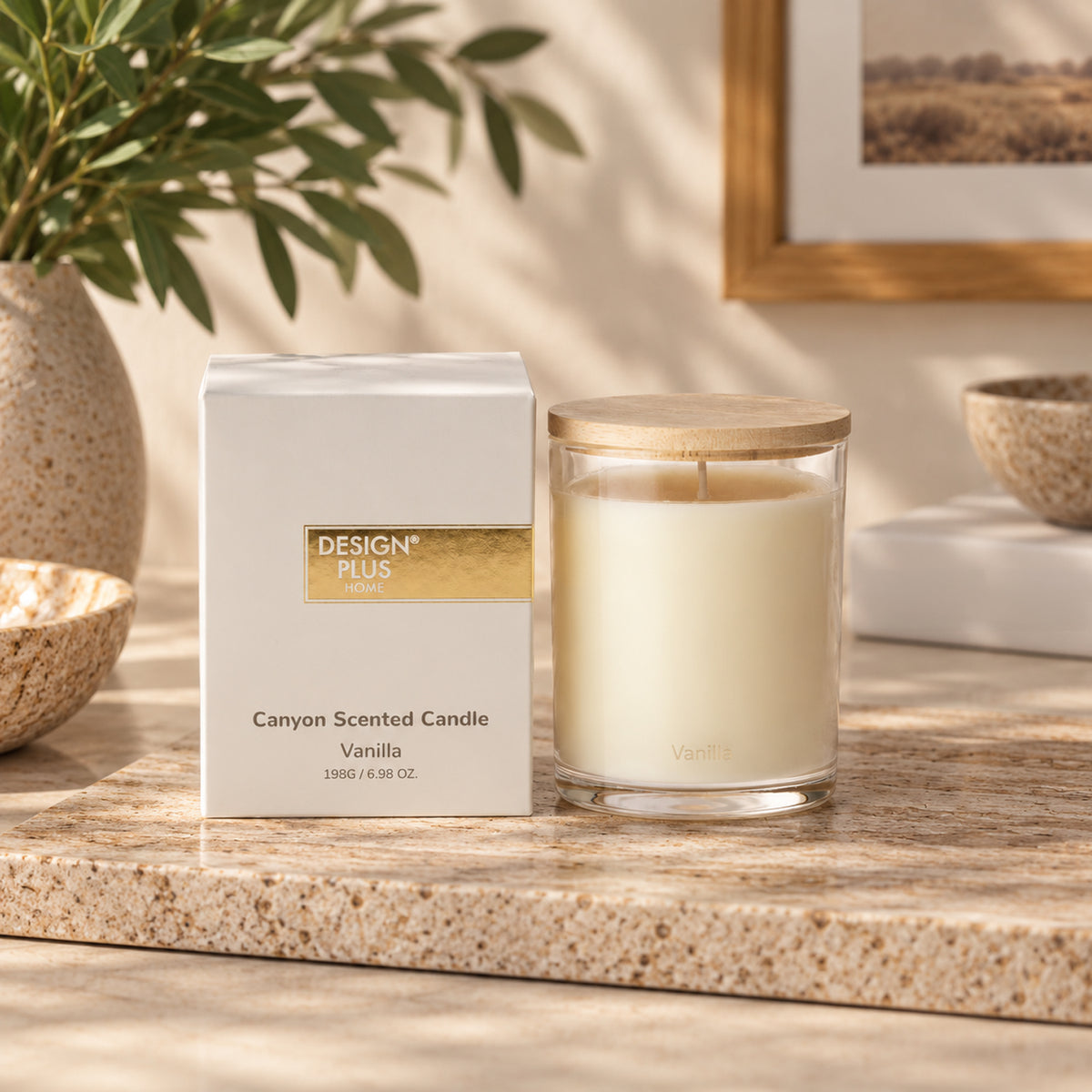 An Vanilla scented candle in a glass jar with a lid sits on a stone countertop beside its box. The box reads 'DESIGN PLUS CANDLE' and 'Canyon Scented Candle Vanilla'.