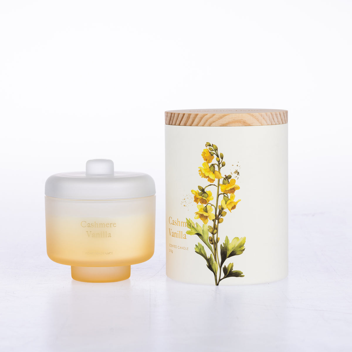 A frosted glass jar candle sits beside its matching cylindrical box packaging.