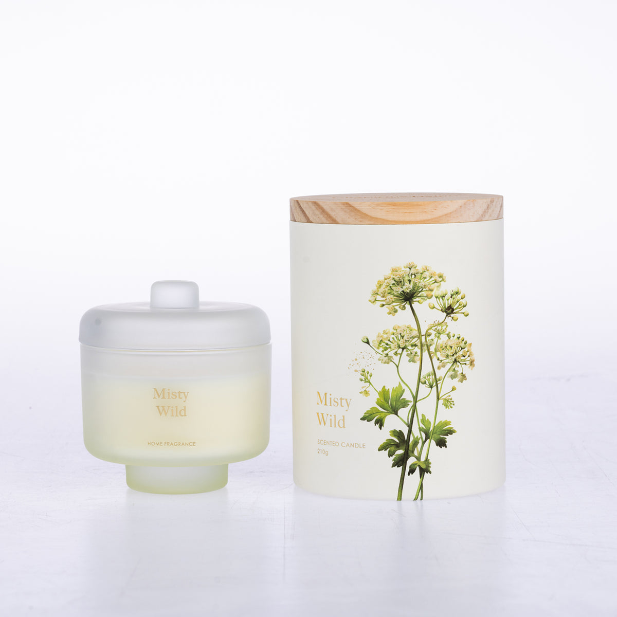 A frosted glass jar candle sits beside its matching cylindrical box packaging.