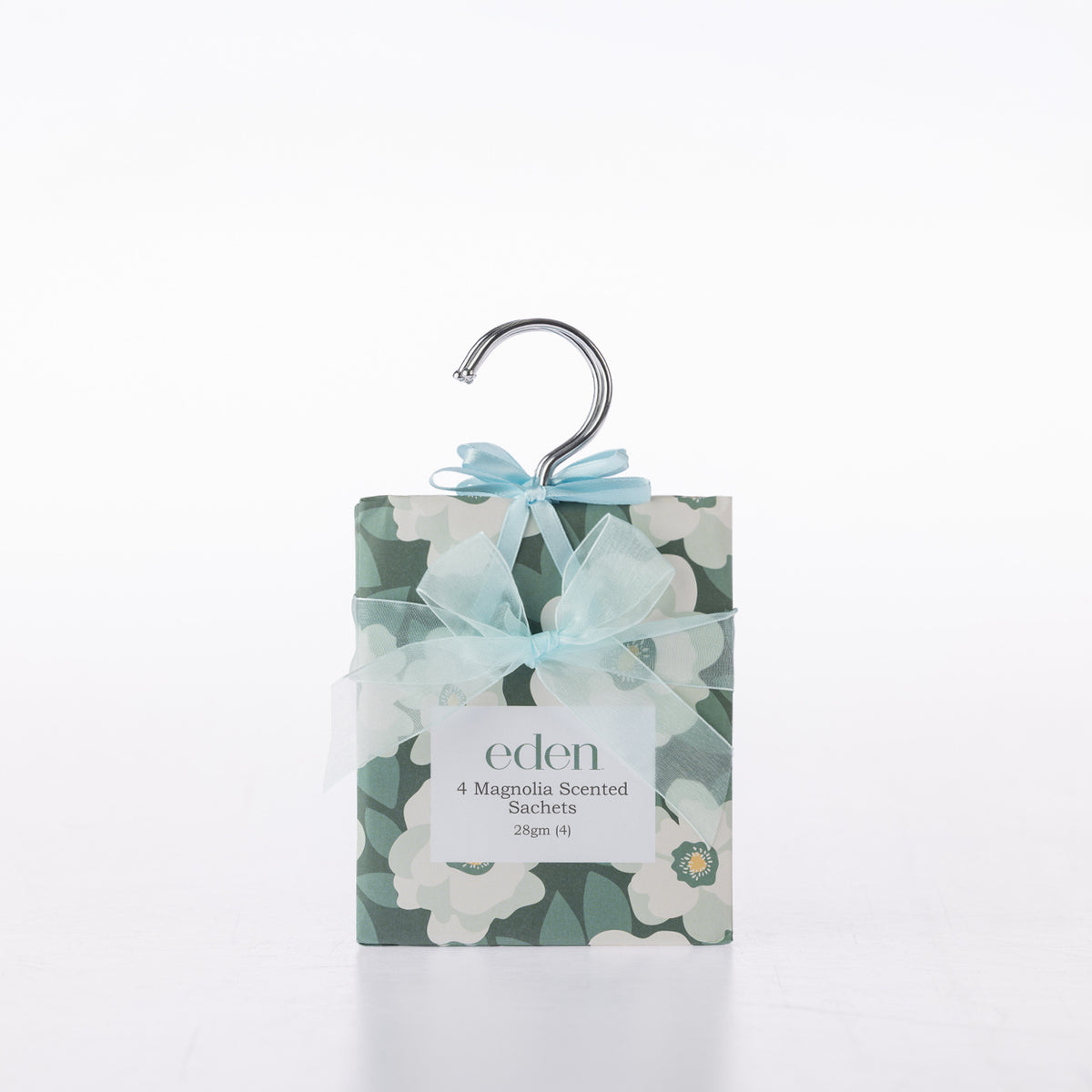 Eden Magnolia Scented Closet Sachets 4 Pack featuring dark green packaging with white magnolia flowers, a pale blue ribbon bow and a silver hanging hook.