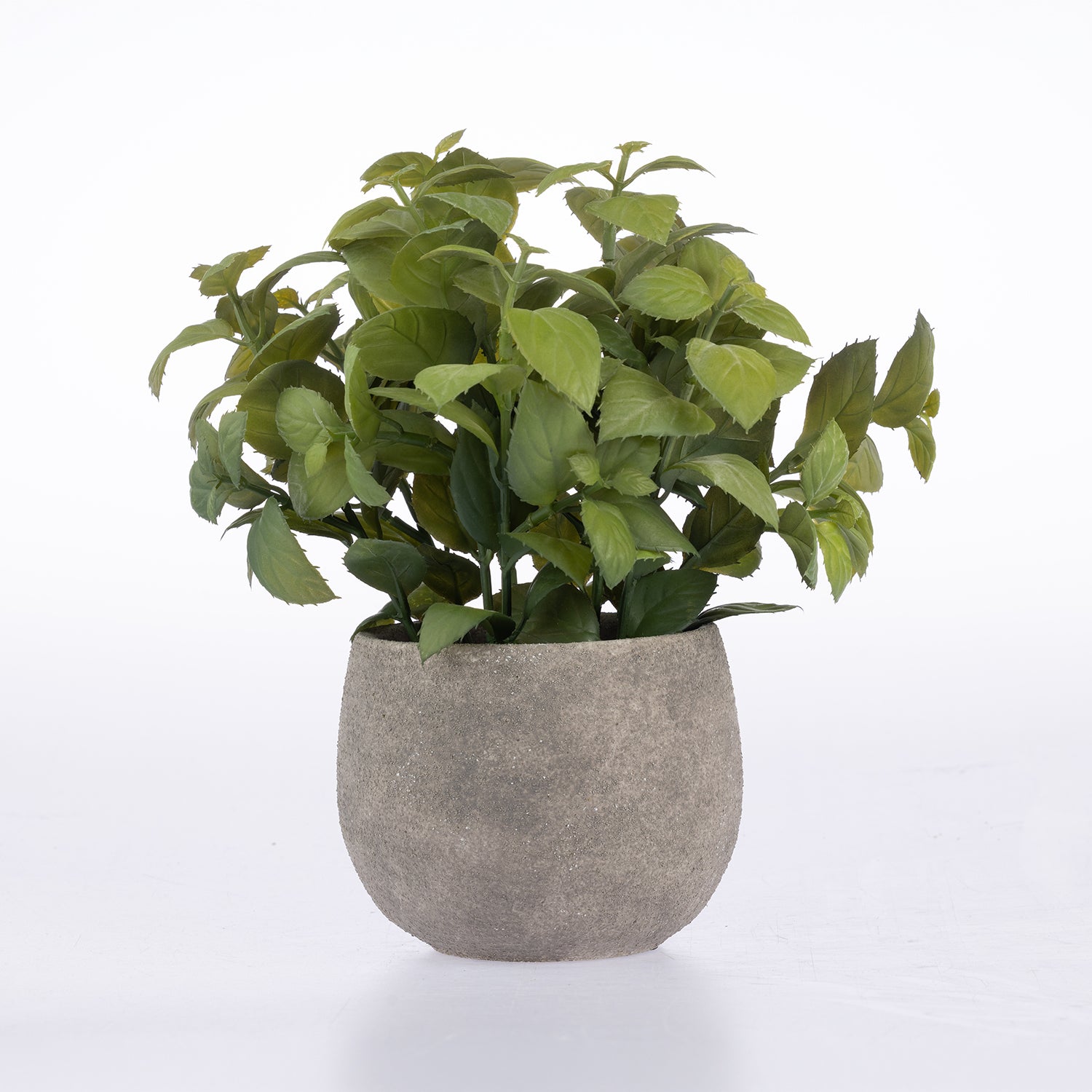 An artificial green leafy plant with realistic stems and leaves, potted in a textured gray concrete-style round planter, set against a seamless white background.