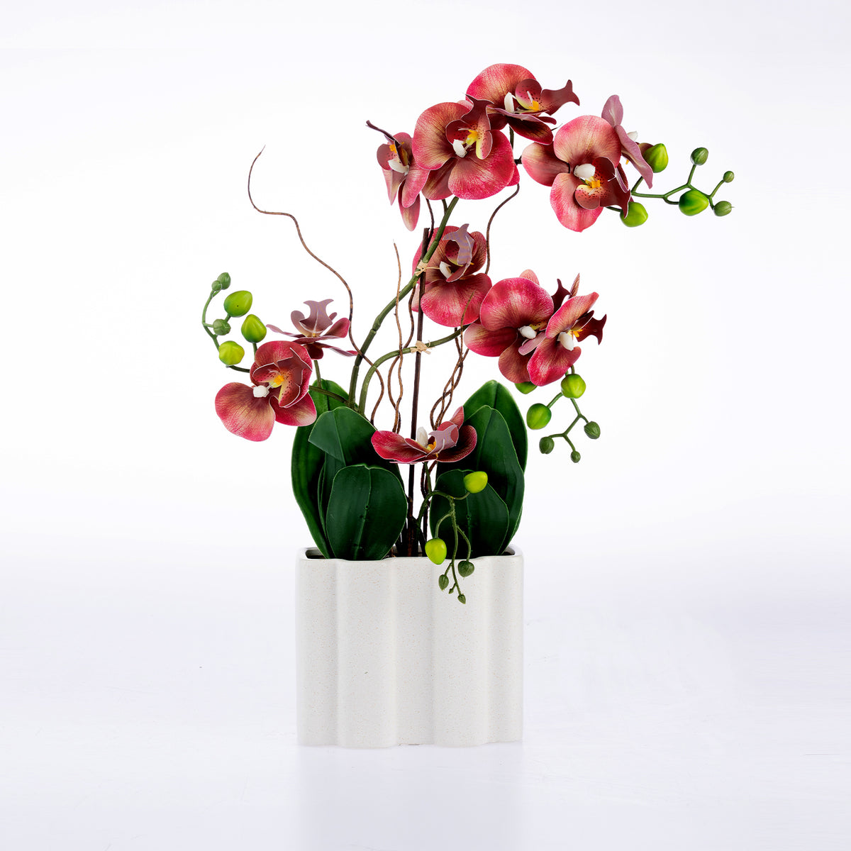 Artificial pink orchid floral arrangement with green leaves and small green berries, displayed in a white rectangular vase against a clean white background.