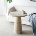 Design Republique Natural Cement Round Side Table styled beside a curved bouclé sofa with a striped mug on top in a bright, modern living room.
