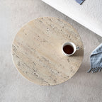 Top-down view of the Design Republique Natural Cement Round Side Table styled beside a sofa with a striped mug on the textured tabletop.