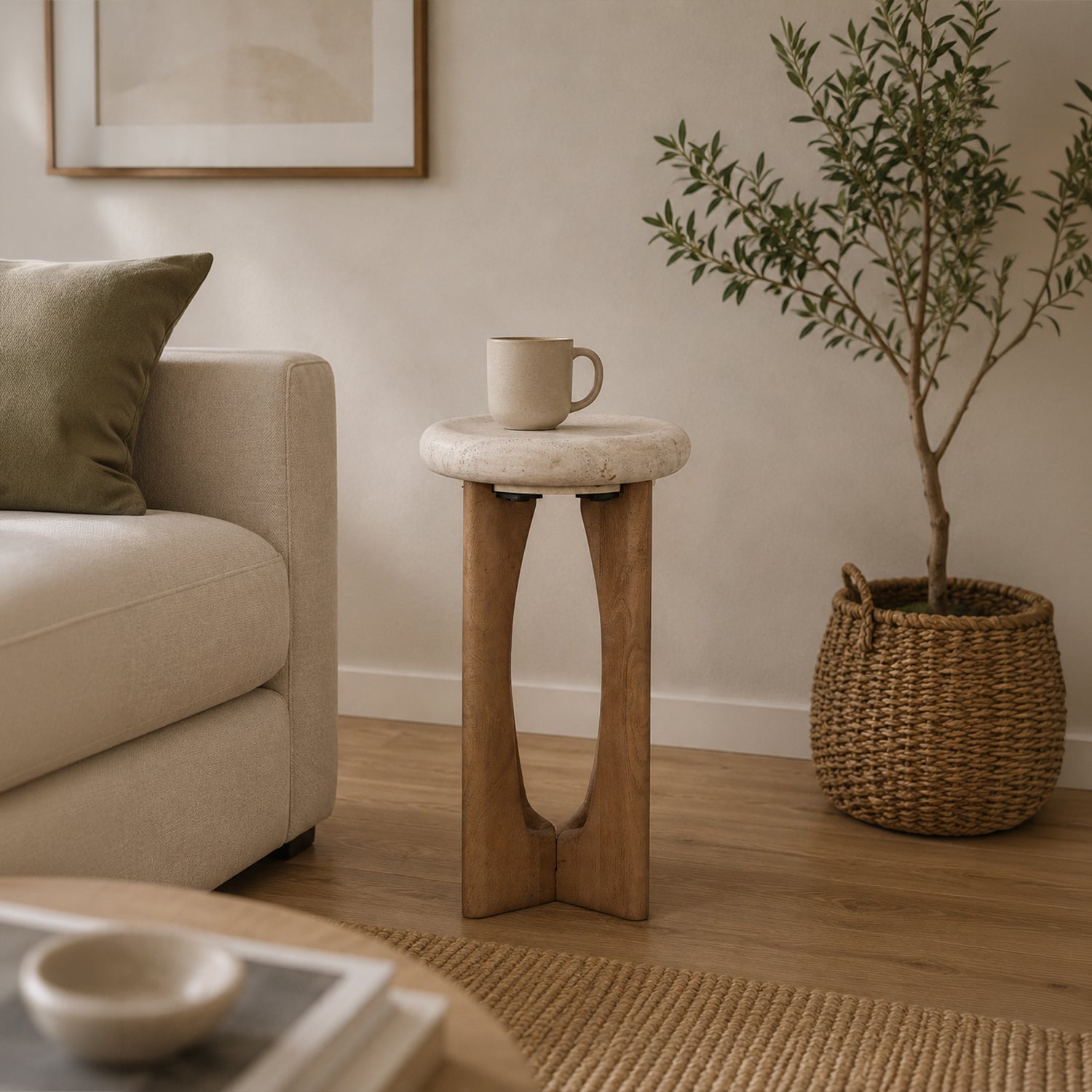 Natural stone and solid wood side table styled beside a neutral sofa in a contemporary living room with a ceramic mug, woven basket planter, and warm natural décor.