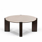 Front angled view of the round coffee table featuring a cream marble top and sculptural dark brown timber legs.