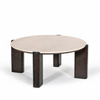Front angled view of the round coffee table featuring a cream marble top and sculptural dark brown timber legs.