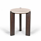 Three-quarter view of the round side table showcasing the cream marble top and chunky dark brown timber legs on a white background.