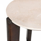 Close-up of the cream marble tabletop with subtle natural veining and a chunky dark brown timber leg detail.