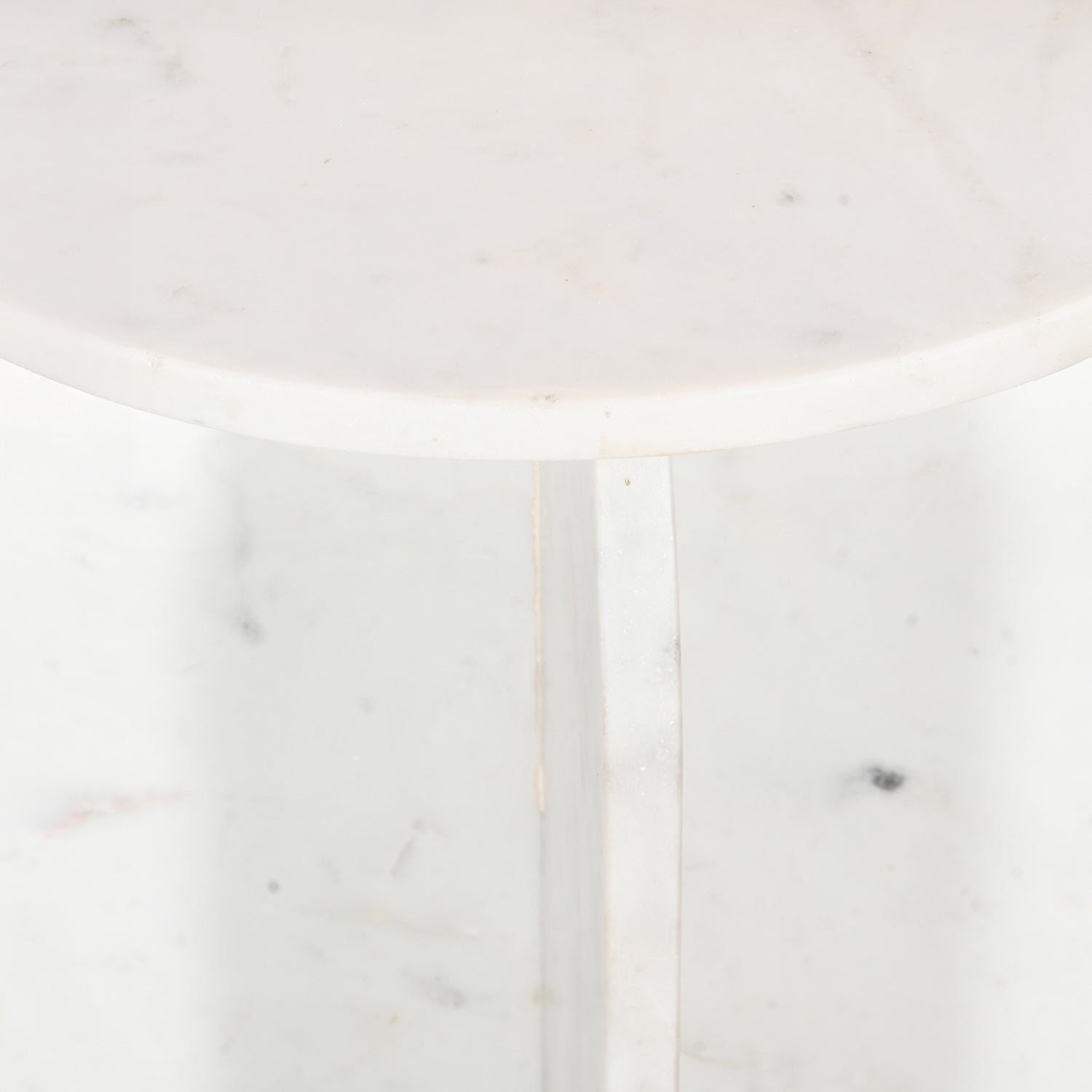 Close-up of the white marble tabletop and intersecting pedestal base, showcasing the natural veining and polished finish.