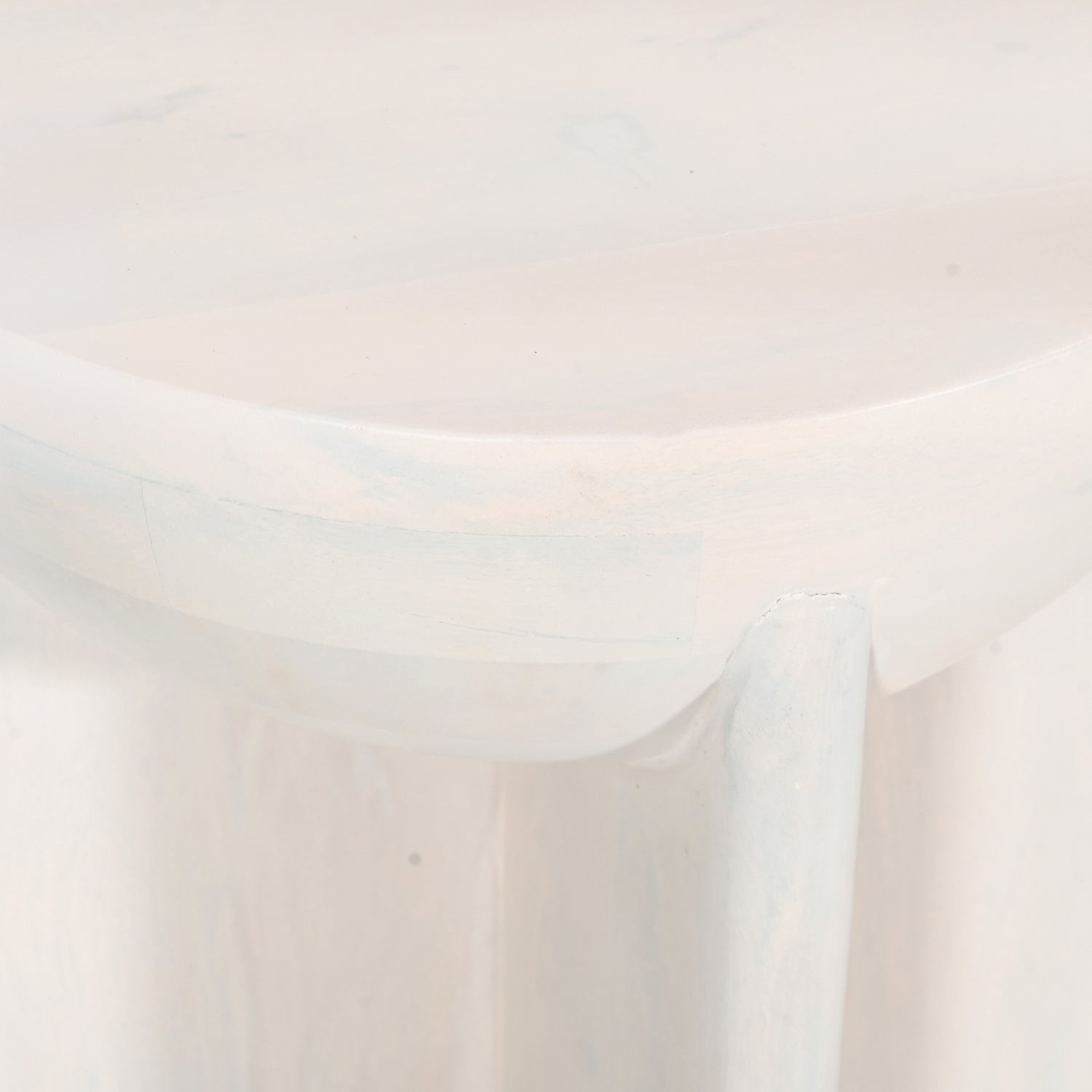 Close-up of the Amparo mango wood side table in white wood, highlighting the smooth rounded edge and subtle natural grain detail.