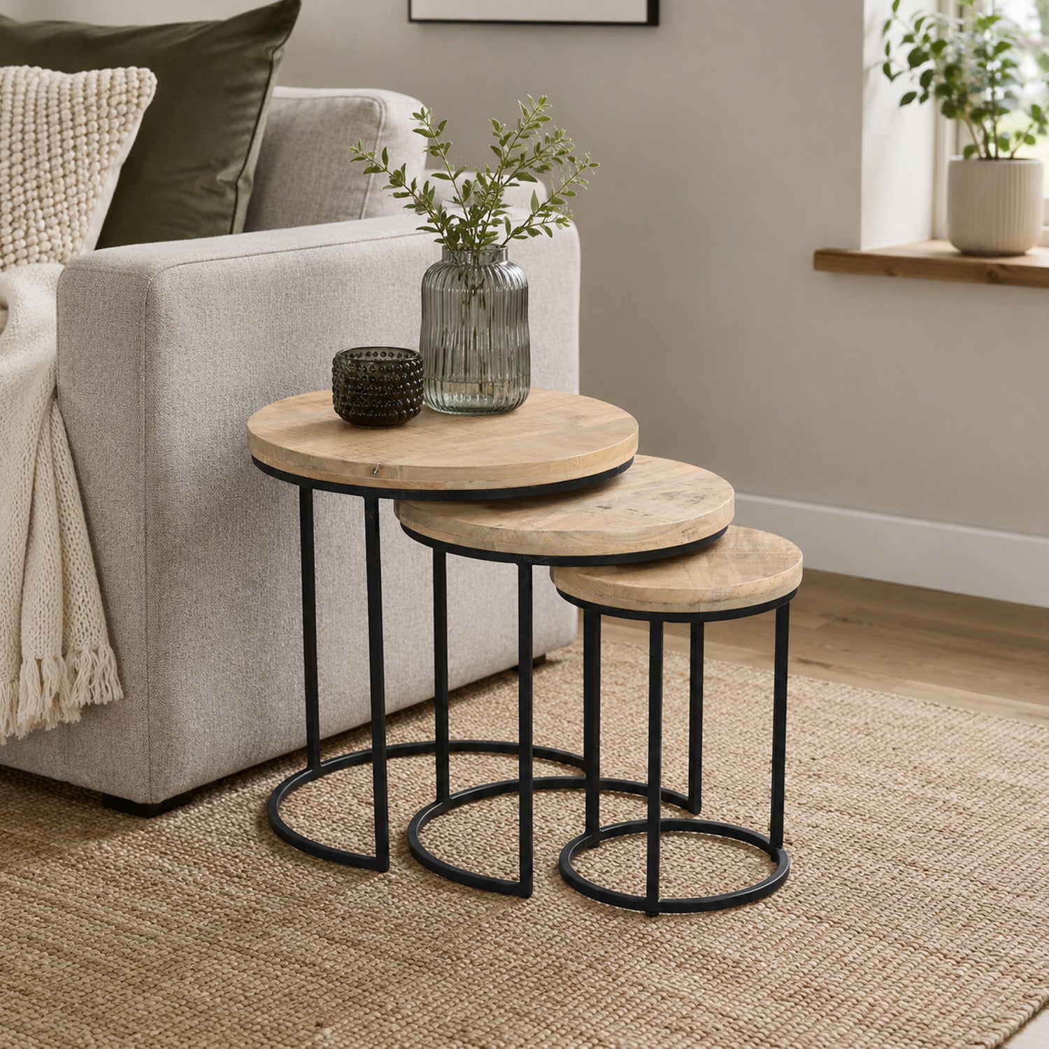 Amparo Reclaimed set of 3 side tables styled beside a sofa in a neutral living room.