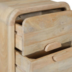 Close-up of the Mango Shona bedside table showing two partially open drawers, rounded edges, natural mango wood grain, and curved timber drawer handles.