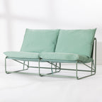 A two-seat cushioned outdoor sofa with a slim green metal frame and green cushions, set against a clean white background.