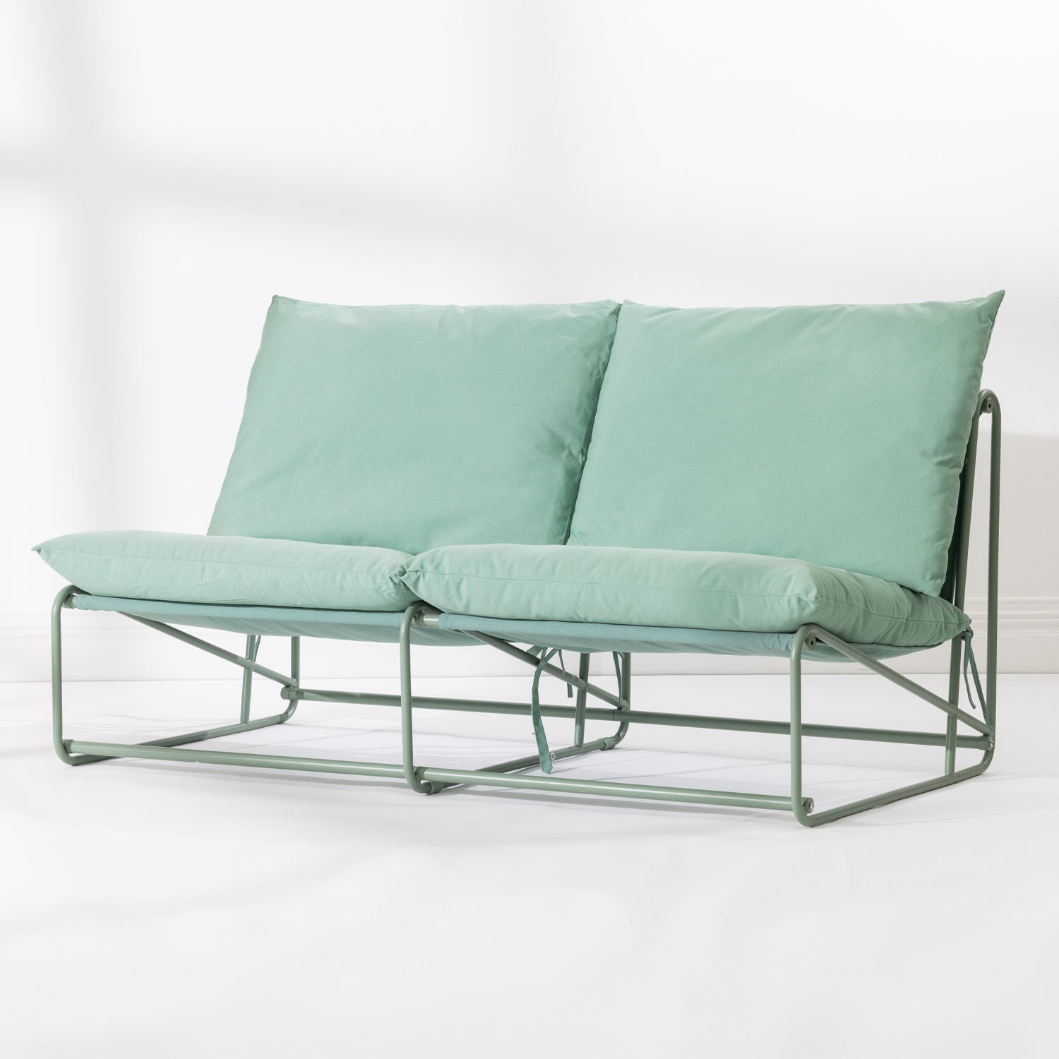 A two-seat cushioned outdoor sofa with a slim green metal frame and green cushions, set against a clean white background.