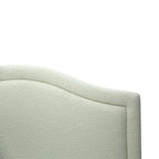 Close up of a Cream bouclé upholstered headboard with a gently curved silhouette and soft textured finish, designed to add warmth and elegance to the bedroom.
