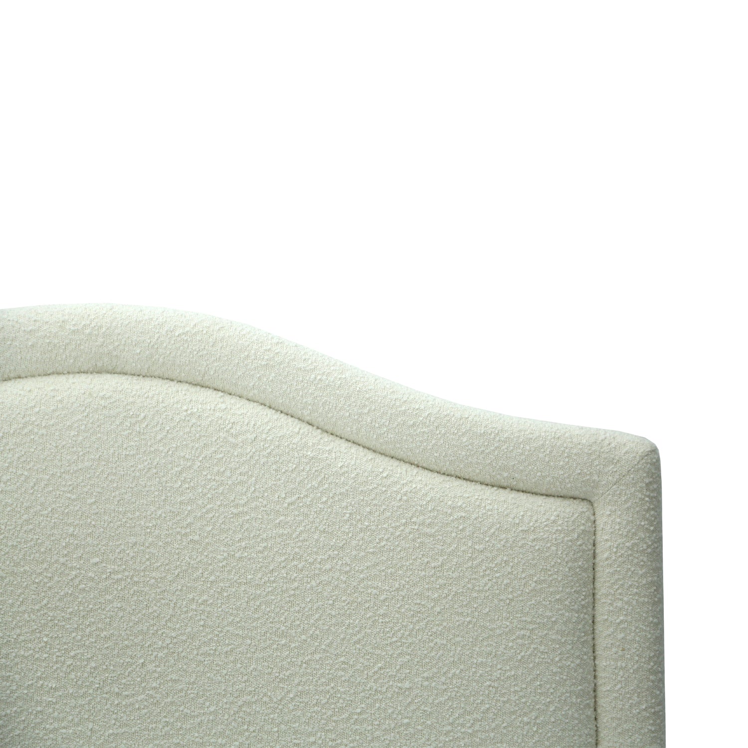 Close up of a Cream bouclé upholstered headboard with a gently curved silhouette and soft textured finish, designed to add warmth and elegance to the bedroom.
