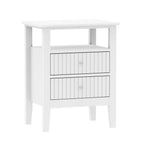 A white wooden nightstand or side table with an open shelf on top and two vertically paneled drawers below is shown against a plain light background.