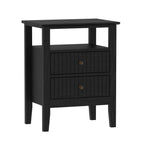 A black wooden nightstand or side table with an open shelf on top and two vertically paneled drawers below is shown against a plain light background.