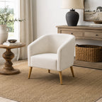 A contemporary natural accent armchair with natural timber legs is styled in a warm, modern country living space featuring woven textures, rustic wood furniture, and soft neutral décor.