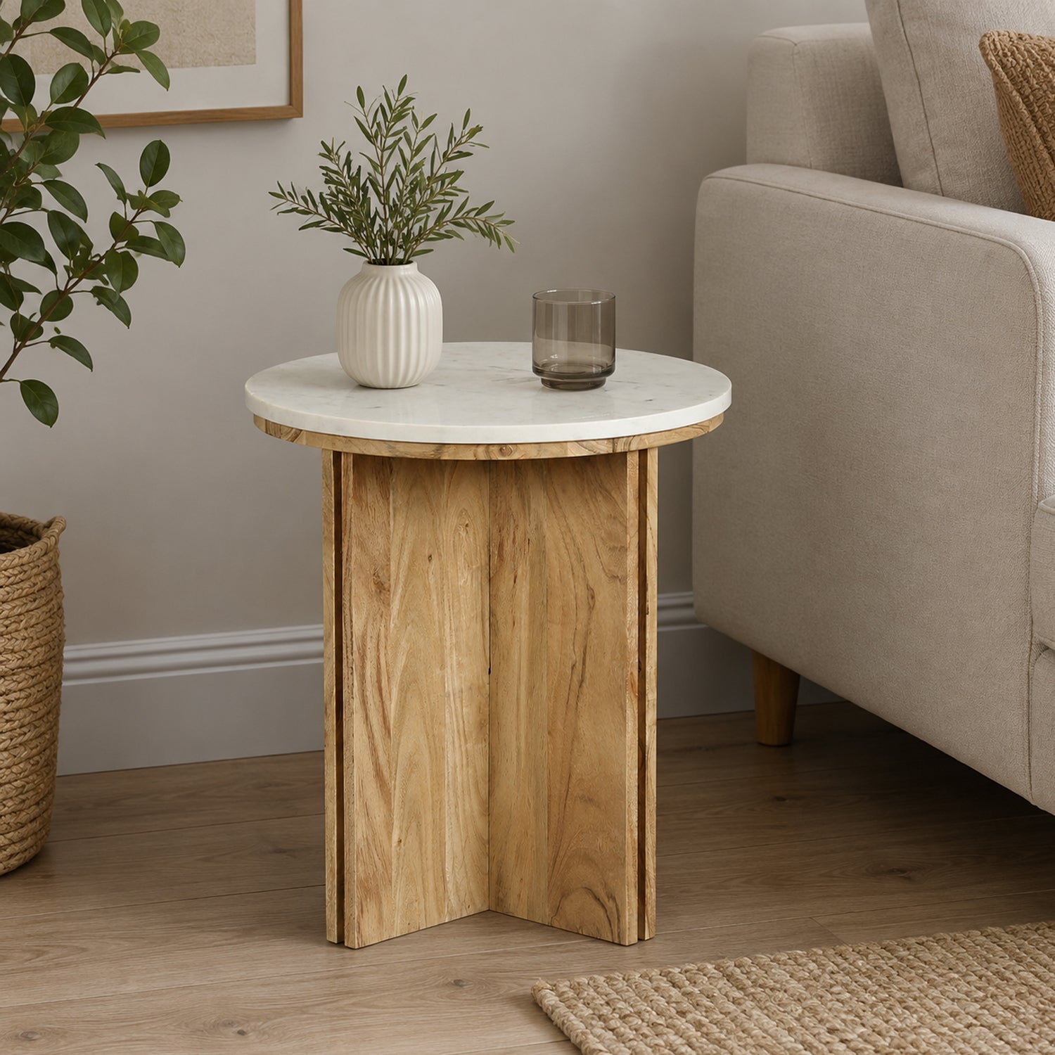 Design Republique Sara marble side table styled in a living room beside a neutral sofa with décor on top.