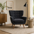 Charcoal button-tufted accent armchair styled in a contemporary living room with natural timber furniture, neutral décor, floor lamp and soft natural light.
