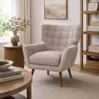 Natural upholstered Alessia armchair styled in a warm contemporary living room with timber furniture, neutral décor, soft natural light and textured furnishings.