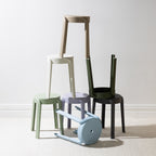A collection of stackable stools in soft contemporary colours is arranged in an artistic display, highlighting their versatile, space-saving design and modern minimalist style.