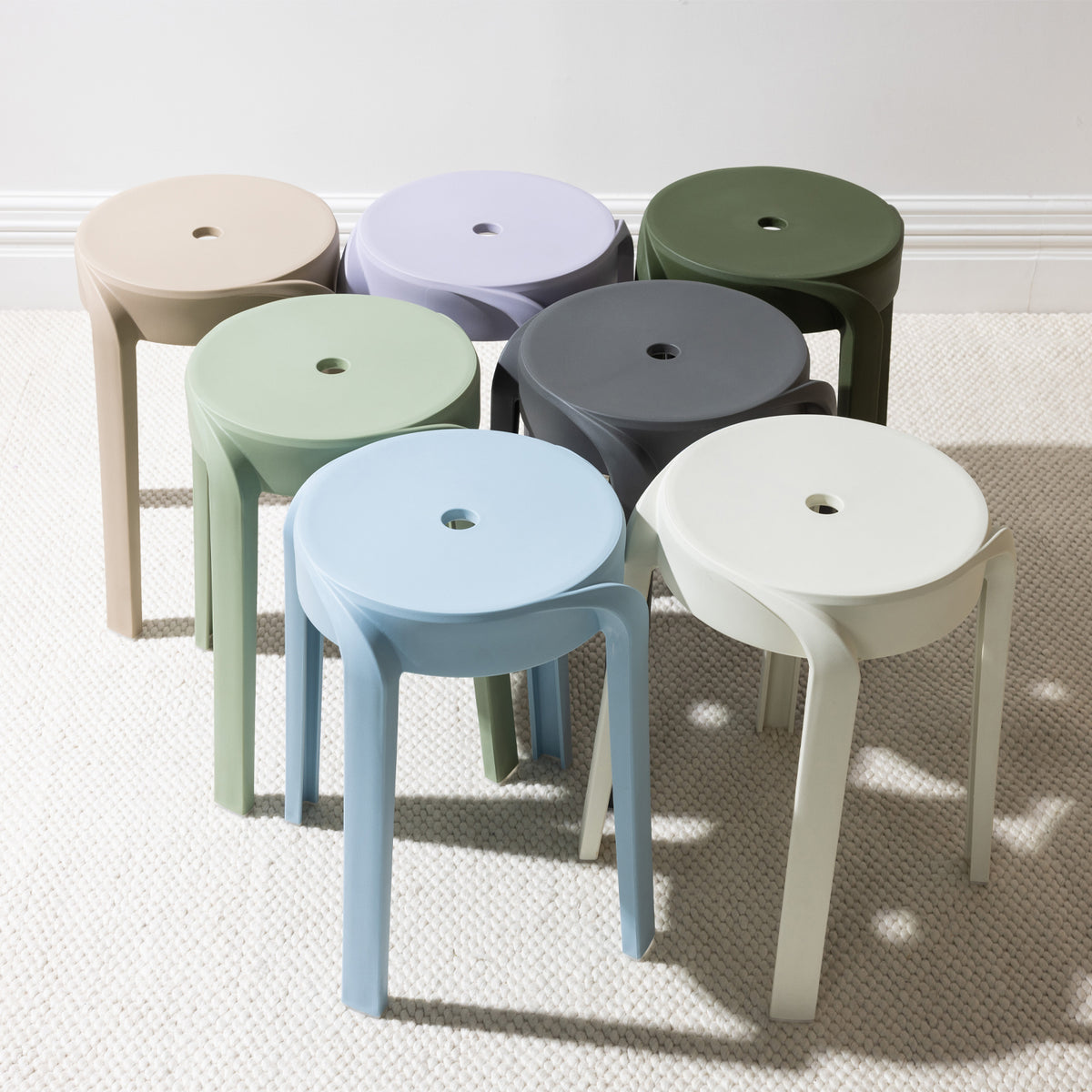 A collection of stackable stools in soft neutral and contemporary colours showcases their clean, minimalist design and versatile style for both indoor and outdoor living.