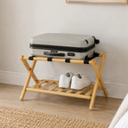 Home Co. Piper Bamboo Luggage Rack in natural bamboo styled in a bedroom with a suitcase on the upper straps and white shoes stored on the lower slatted shelf.